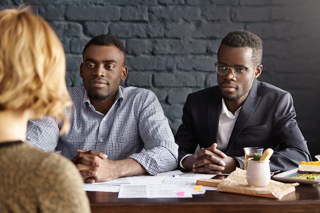 Deux spécialistes des ressources humaines afro-américains attrayants menant un entretien d'embauche avec une candidate