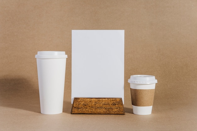 Photo gratuite deux tasses à café à côté du tableau blanc