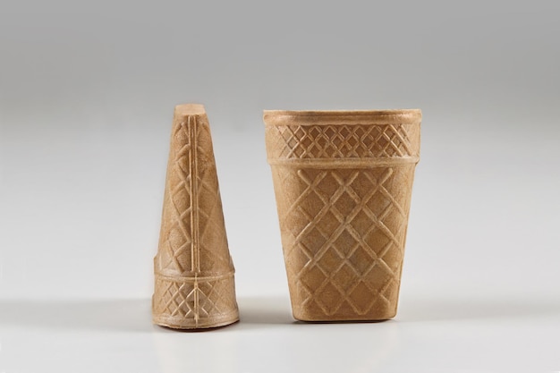 Deux tasses de gaufrettes vides, délicieuses et grandes pour la crème glacée isolées sur fond blanc. Concept de nourriture et de friandises. Maquette, modèle pour votre publicité et votre design. Gros plan, copiez l'espace