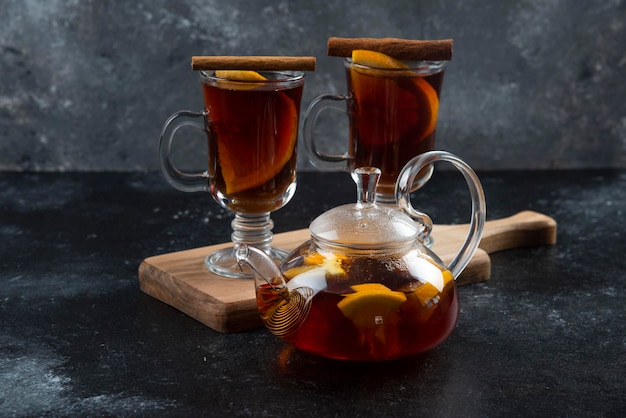 Photo gratuite deux tasses en verre avec du thé et des bâtons de cannelle.