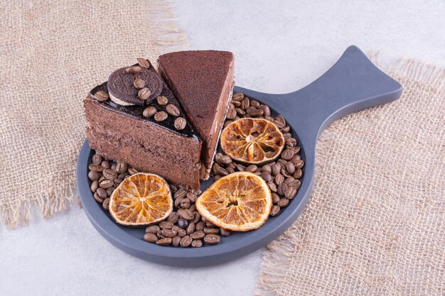 Deux tranches de gâteaux au chocolat avec des grains de café et des tranches d'orange. photo de haute qualité