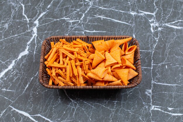 Deux types de chips croustillantes dans un panier en bois.