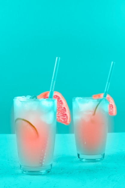 Photo gratuite deux verres de cocktail de pamplemousse rafraîchissement sur fond de menthe