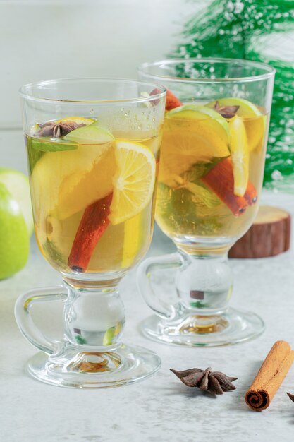 Deux verres de cocktail de pommes fraîches sur une surface grise.