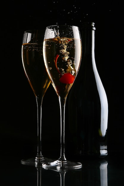 Photo gratuite deux verres élégants avec du champagne et des cerises