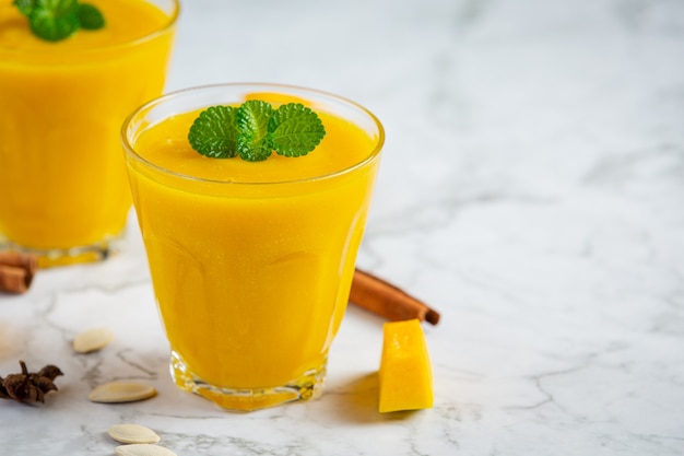 Deux verres de place de jus de citrouille sur un sol en marbre blanc