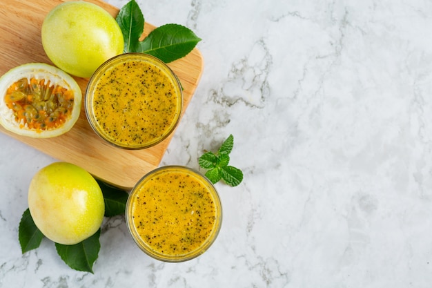 Deux verres de place de jus de fruit de la passion sur un sol en marbre blanc