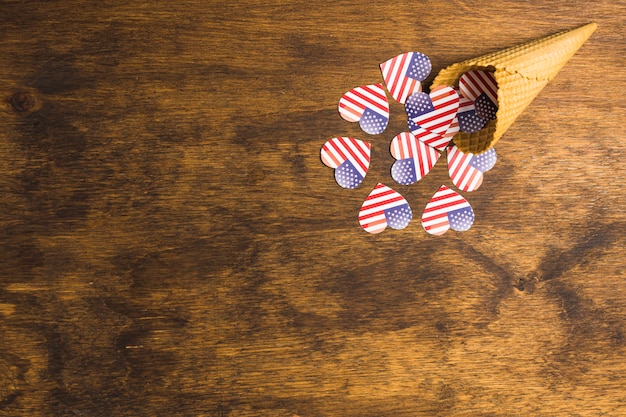 Photo gratuite déversé en forme de coeur de drapeau américain renversé du cône de gaufre sur le bureau en bois