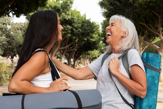 Photo gratuite différence d'âge entre amies se réunissant pour le yoga en plein air