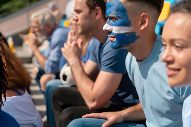 Photo gratuite différentes personnes regardant une équipe de football