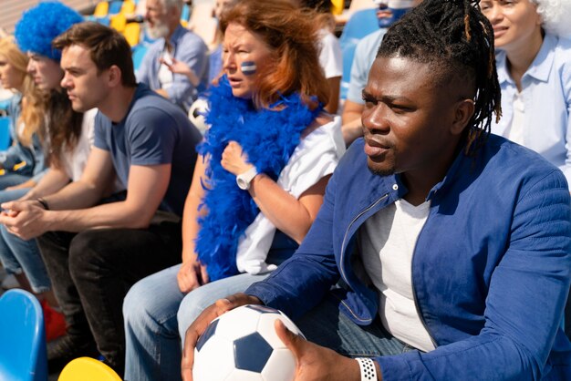 Différentes personnes regardant une équipe de football