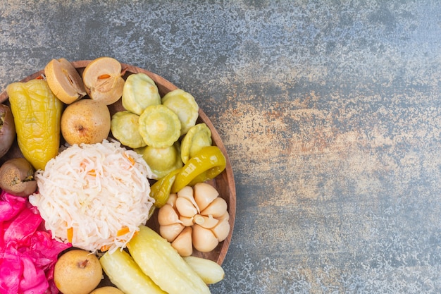 Différents légumes sur une assiette en bois.