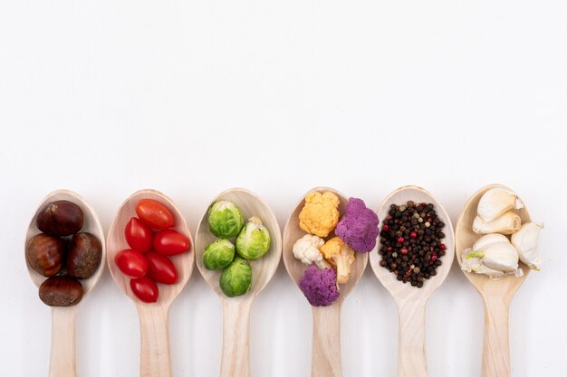 Différents légumes sur des cuillères en bois