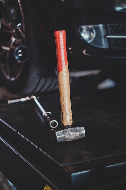 Différents outils comme une clé et un marteau au service automatique sur la plate-forme noire.