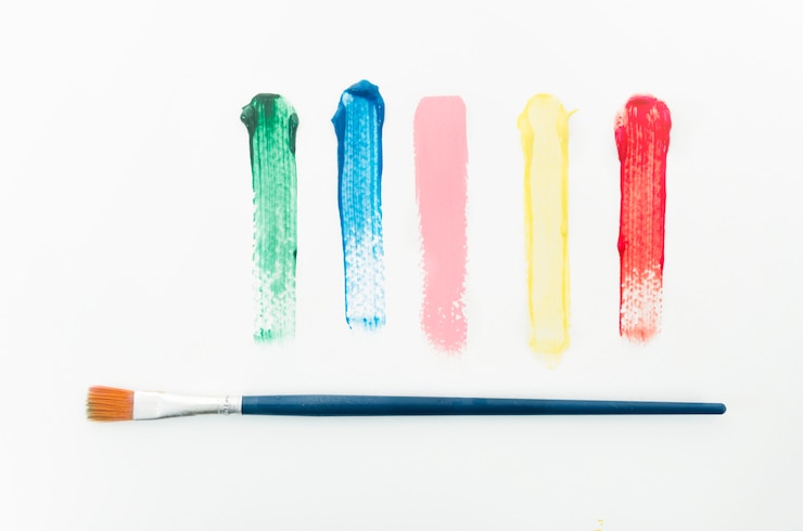 Photo gratuit différents traits colorés à côté du pinceau