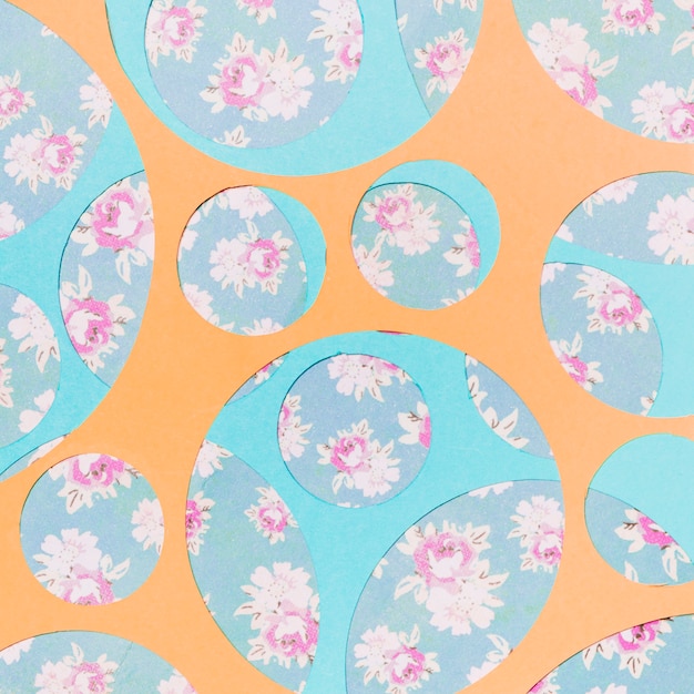 Photo gratuite différents types de cercles géométriques sur le papier peint à fleurs