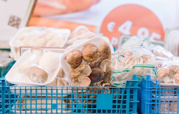 Différents types de champignons emballés dans une caisse bleue