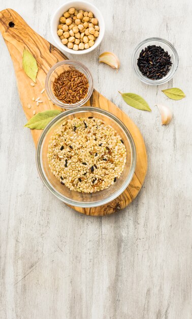 Différents types de riz dans des bols sur une planche de bois