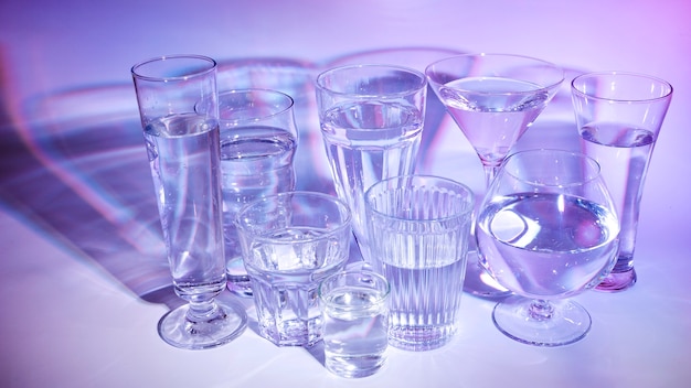 Différents types de verres avec du liquide sur un fond coloré