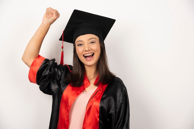 Diplômé frais célébrant son succès sur fond blanc.