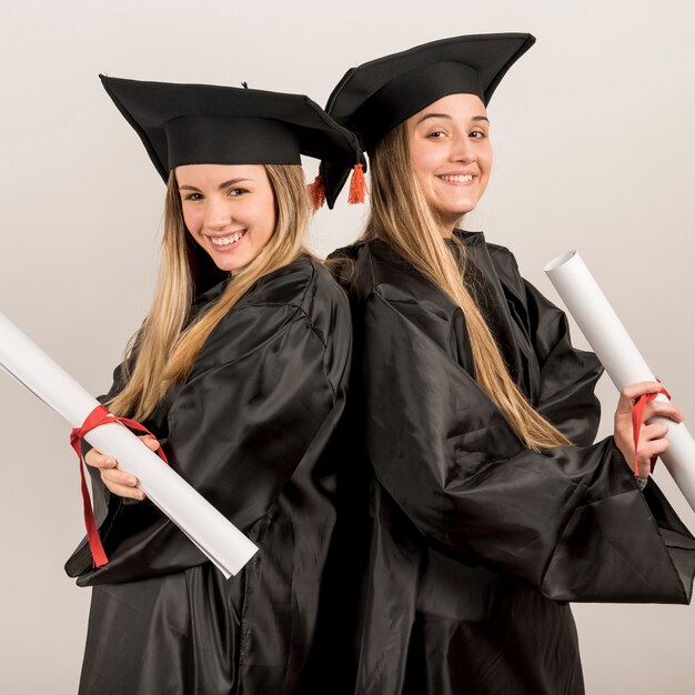 Diplômé moyen posant et souriant à la caméra