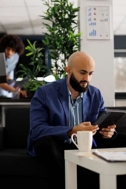 Photo gratuite un directeur exécutif arabe vérifiant un plan d'affaires sur une tablette numérique