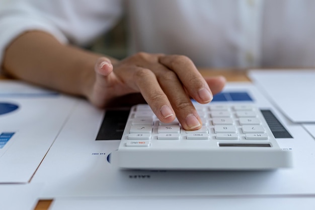 Le directeur financier de l'entreprise utilise une calculatrice, il utilise une calculatrice pour calculer les chiffres dans les documents financiers de l'entreprise que les employés du service créent comme documents de réunion.