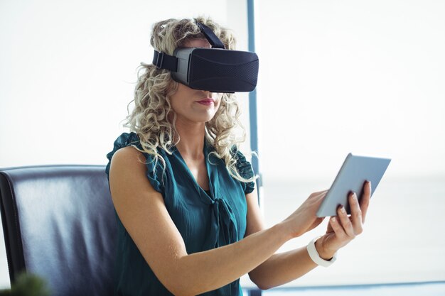 Dirigeant d'entreprise utilisant un casque de réalité virtuelle et une tablette numérique