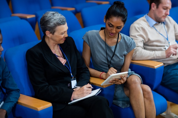 Dirigeants d'entreprises participant à une réunion d'affaires à l'aide d'une tablette numérique