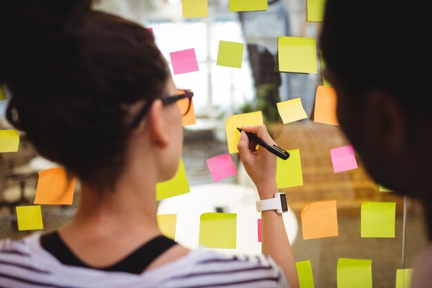 Les dirigeants d&#39;entreprises qui écrivent sur des notes autocollantes