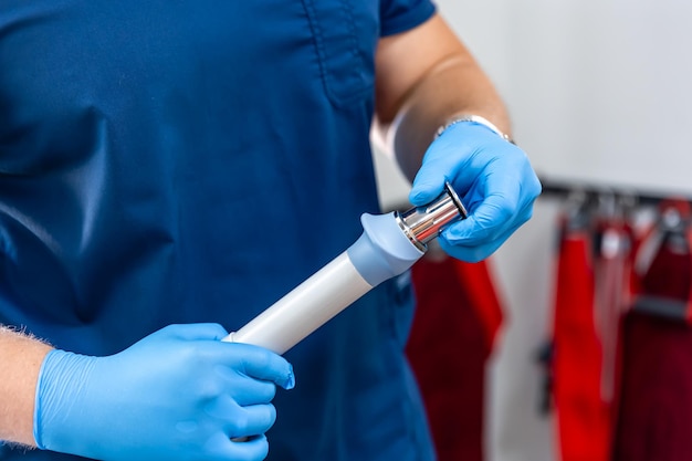 Photo gratuite dispositif de thérapie par ondes de choc avec des mains de médecin dans des gants en caoutchouc