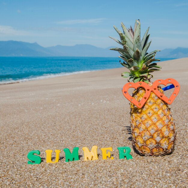Disposition créative de l&#39;ananas sur le sable