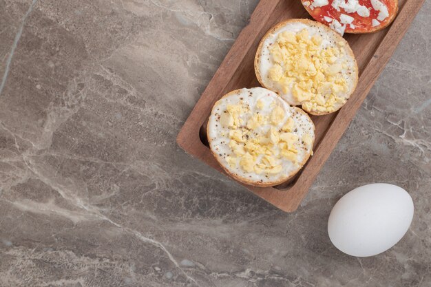 Divers bruschetta sur plaque en bois avec des œufs. Photo de haute qualité