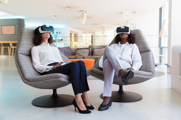 Divers collègues féminines dans des lunettes de réalité virtuelle