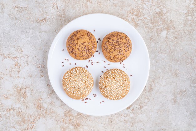 Divers cookies sur une assiette, sur la table en marbre.