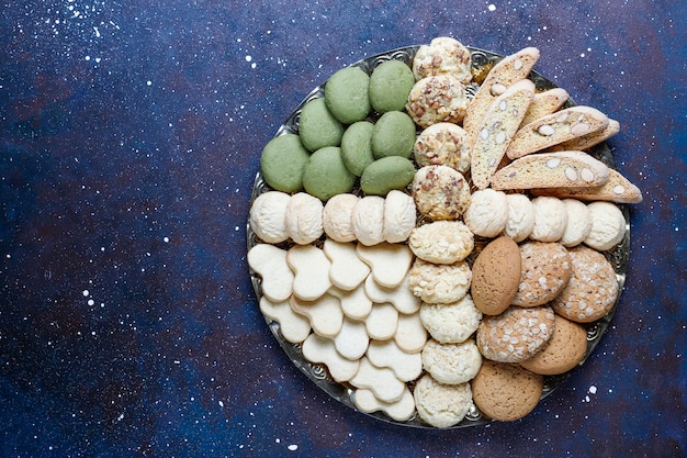 Divers cookies dans un plateau en bois sur fond gris