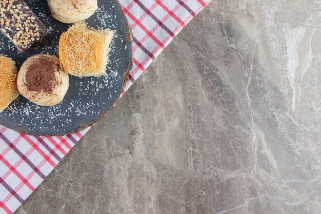 Divers desserts sur une planche sur torchon sur marbre.