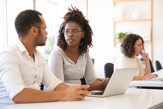 Photo gratuite divers étudiants assis au bureau avec ordinateur portable