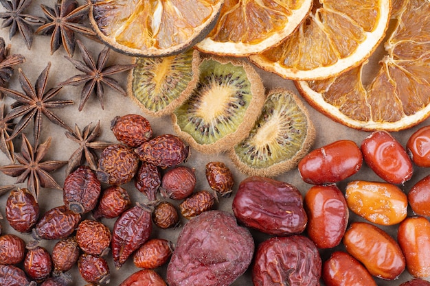 Divers fruits secs et clous de girofle sur pièce en bois.