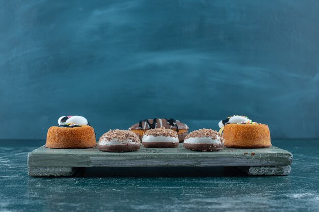 Divers gâteaux sur une planche , sur fond bleu. photo de haute qualité