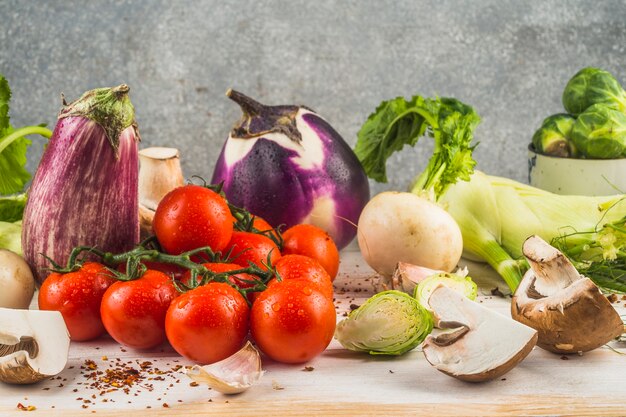 Divers légumes biologiques et flocons de piment rouge sur une table en bois