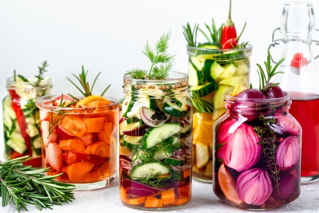 Divers légumes marinés dans des jarres de verre Légumes fermentés mixtes