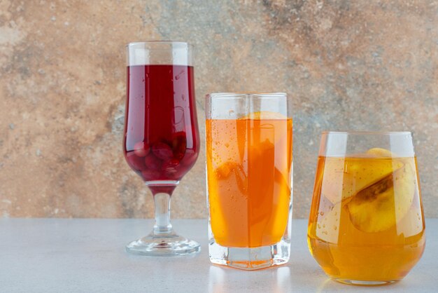 Divers limonades aux fruits sur table bleue.