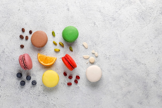 Divers macarons aux pistaches, fruits, baies, grains de café.