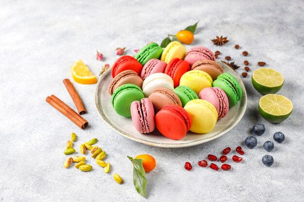 Divers macarons aux pistaches, fruits, baies, grains de café.