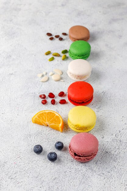 Divers macarons aux pistaches, fruits, baies, grains de café.