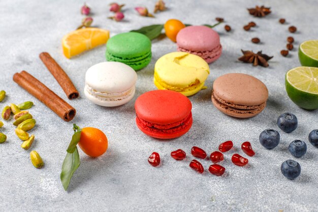 Divers macarons aux pistaches, fruits, baies, grains de café.