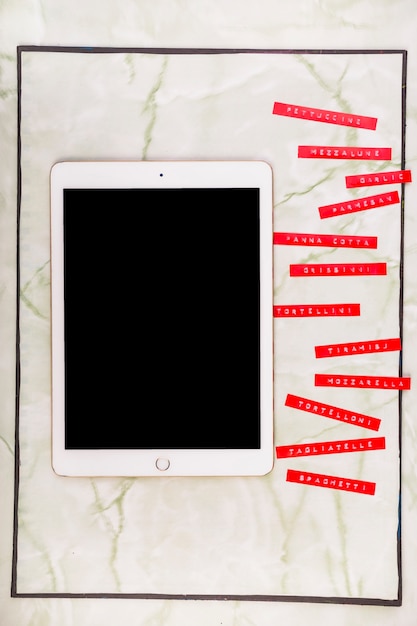 Photo gratuite divers menus à côté de la tablette numérique avec écran noir blanc