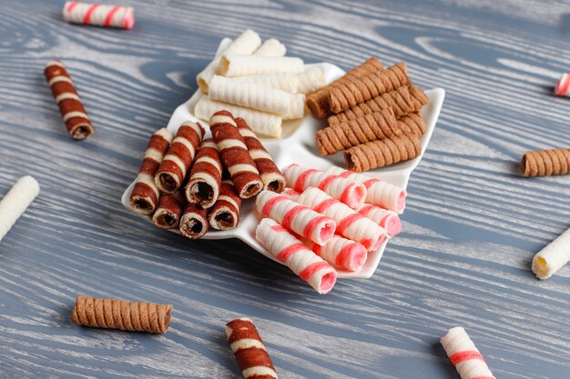 Divers rouleaux de gaufres dans des assiettes en céramique, vue du dessus.