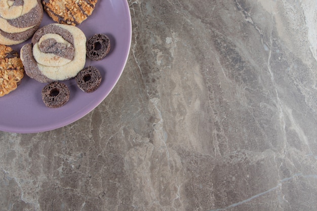 Diversement des biscuits et des anneaux de maïs sur une plaque en marbre.
